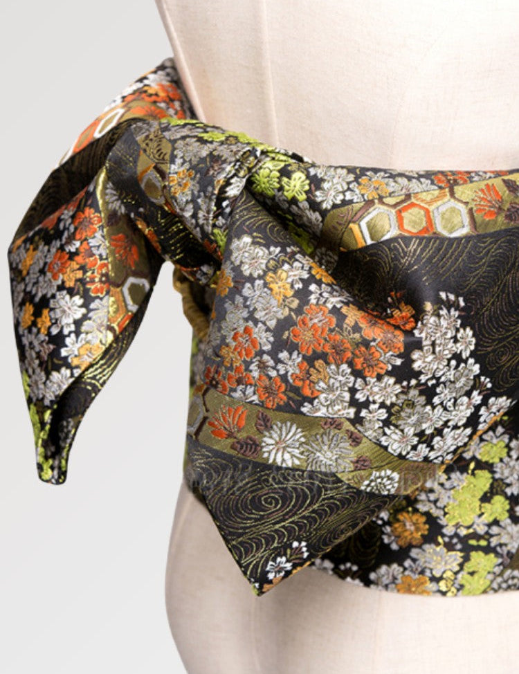 A traditional camel colored obi belt for women with a floral pattern