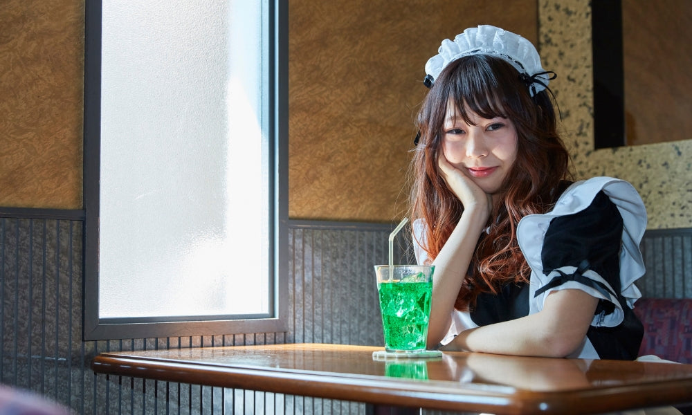 Server in maid uniform at a table in a Japanese maid cafe