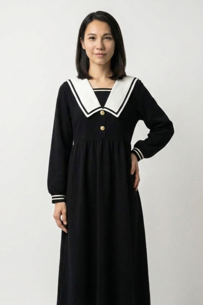 Japanese dress collection: woman wearing a long navy sailor collar dress with white trim and gold buttons, seifuku-inspired cut