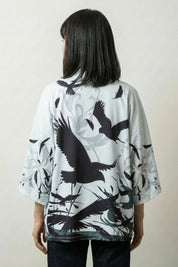 Back view of the Hisae kimono jacket: black cranes rising through tall reeds and grasses drawn like a sumi-e brush painting on cream