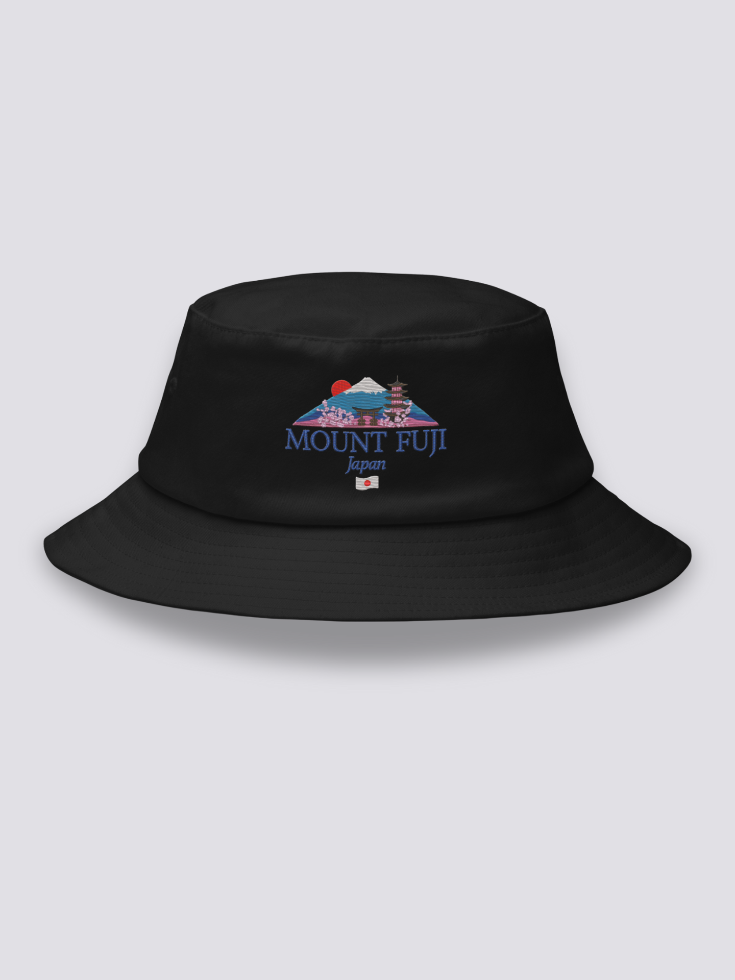 Black bucket hat with an embroidered Mount Fuji scene framed by a torii, a pagoda, a red sun and cherry blossom above MOUNT FUJI lettering