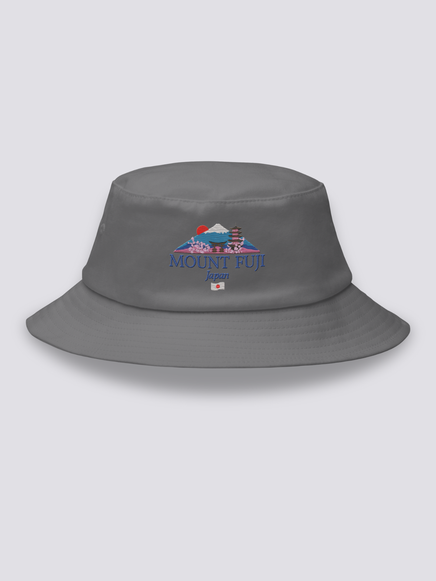 Grey bucket hat with an embroidered Mount Fuji scene framed by a torii, a pagoda, a red sun and cherry blossom above MOUNT FUJI lettering