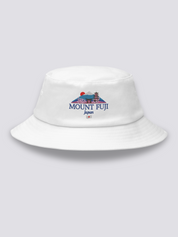 Khaki bucket hat with an embroidered Mount Fuji scene framed by a torii, a pagoda, a red sun and cherry blossom above MOUNT FUJI lettering