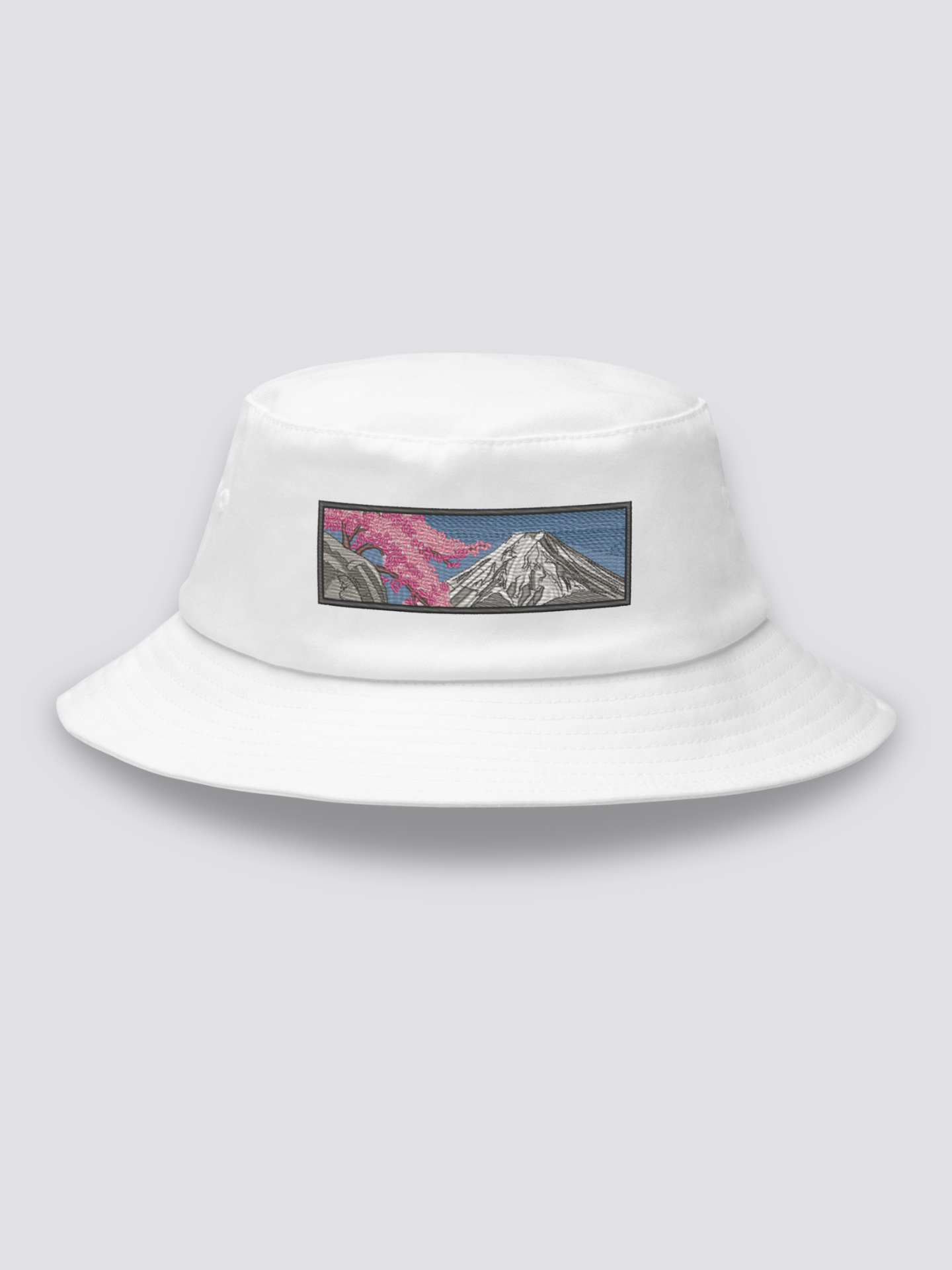 Khaki bucket hat with an embroidered sumi-e patch of Mount Fuji in white and grey with a cherry branch over a slate sky