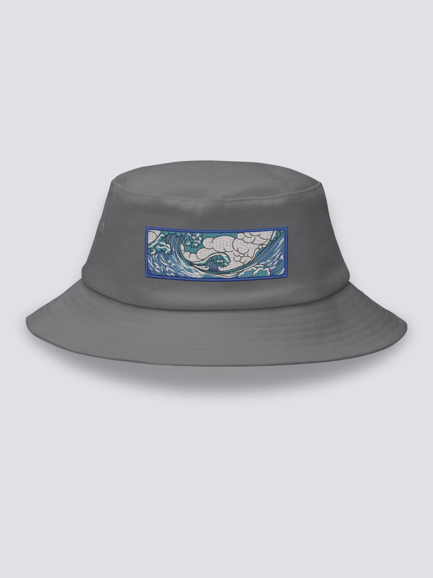 Grey bucket hat with an embroidered horizontal patch of the Great Wave in clawed white foam over blue and turquoise water