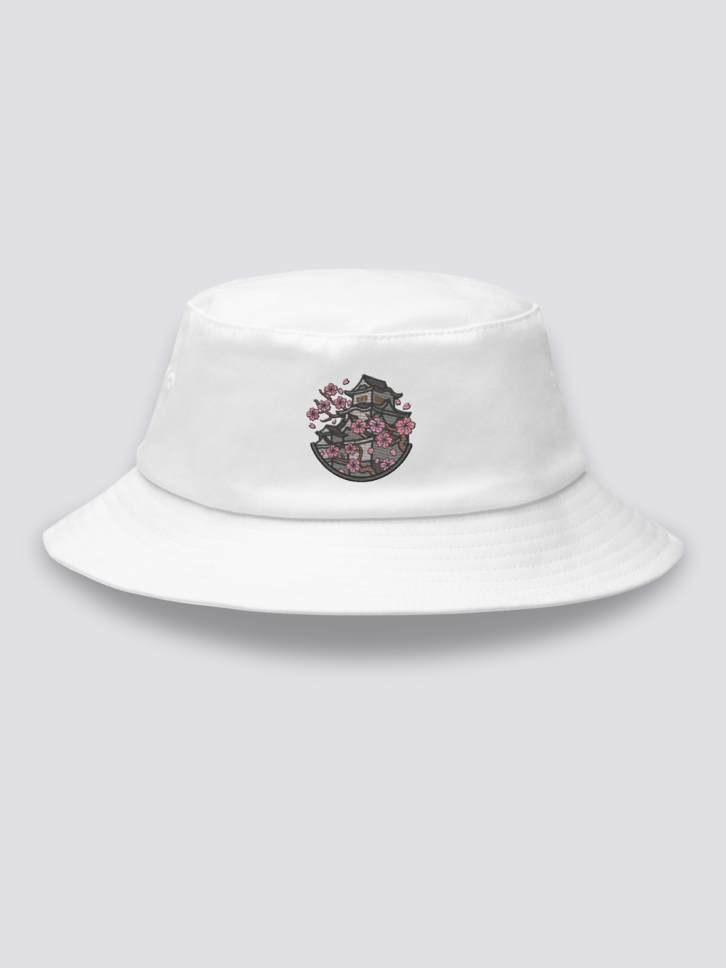 White bucket hat with an embroidered medallion of Himeji Castle framed by pink cherry blossom branches