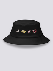 Black bucket hat with four embroidered icons in a row: an origami crane, geta sandals, a cherry blossom and a red koi carp