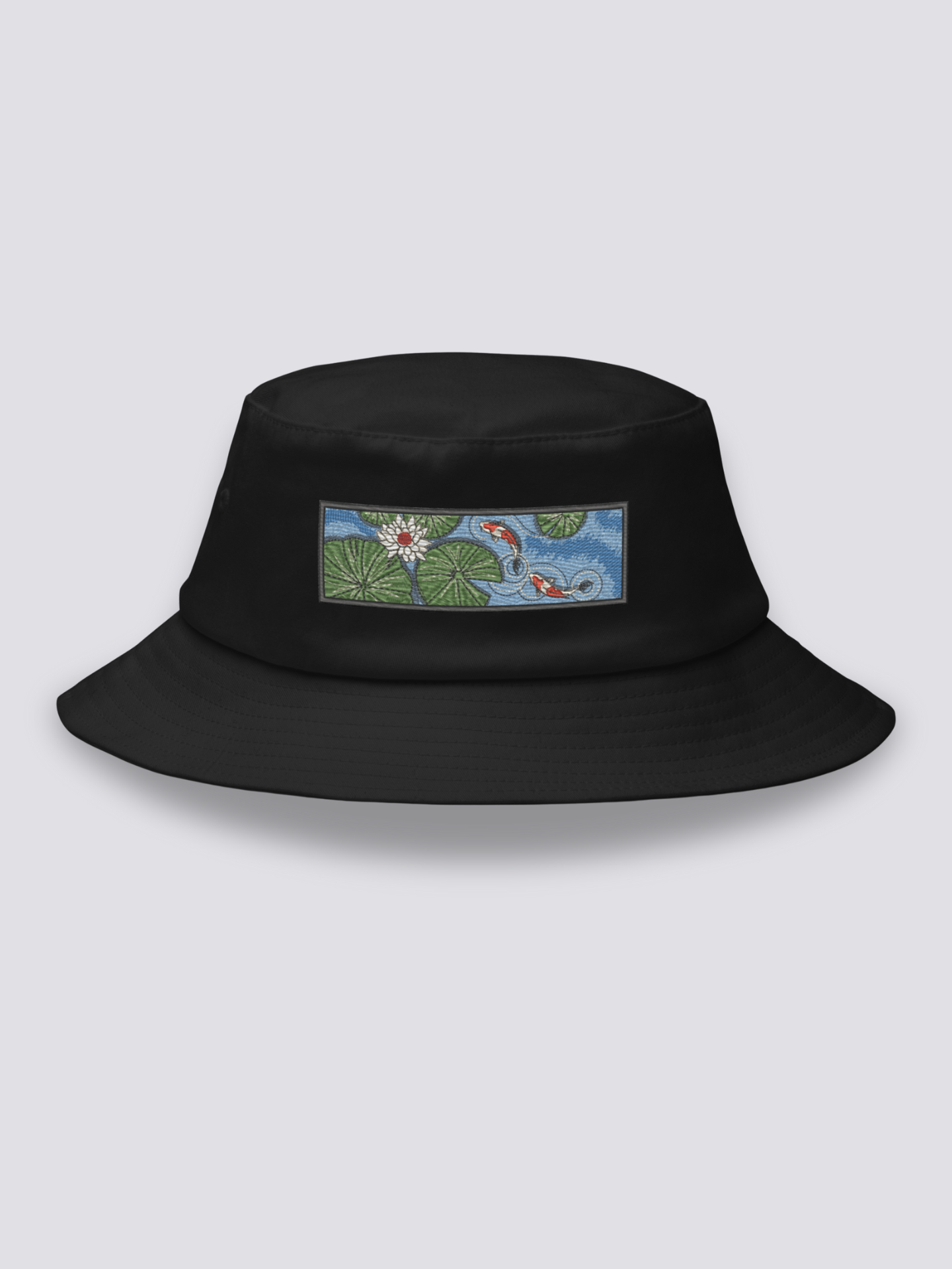 Black bucket hat with an embroidered patch of two red and white koi carp among lily pads and a white lotus