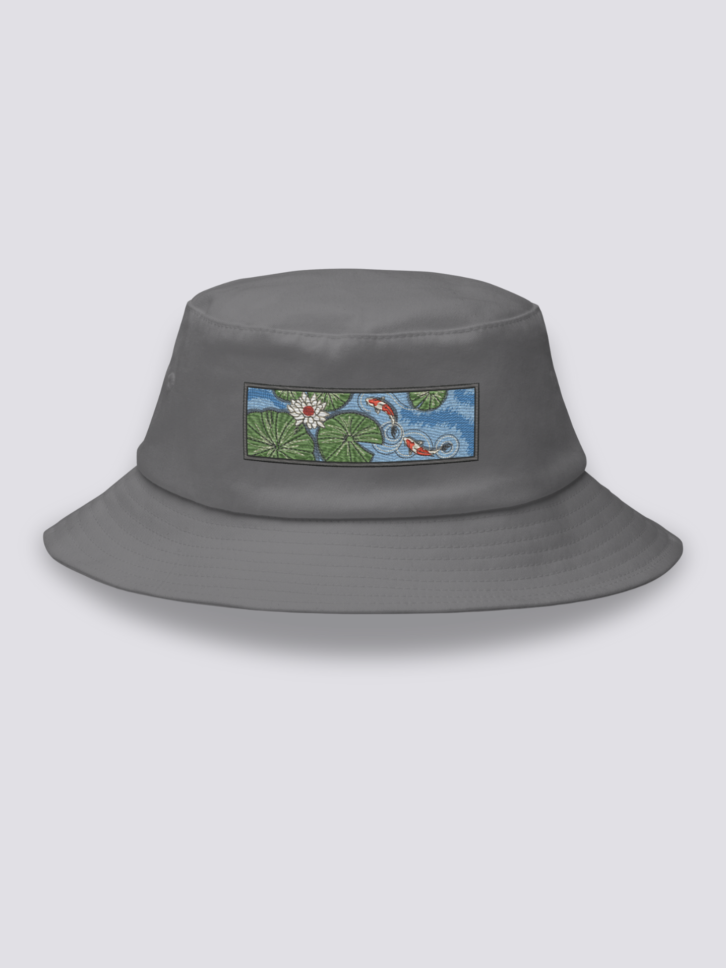 White bucket hat with an embroidered patch of two red and white koi carp among lily pads and a white lotus