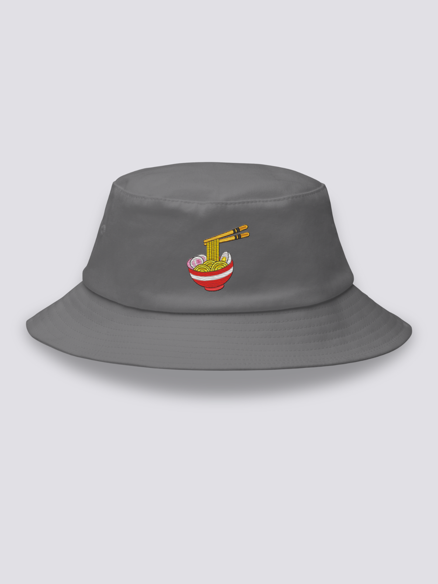 Grey bucket hat with an embroidered steaming ramen bowl, noodles lifted on chopsticks and pink narutomaki