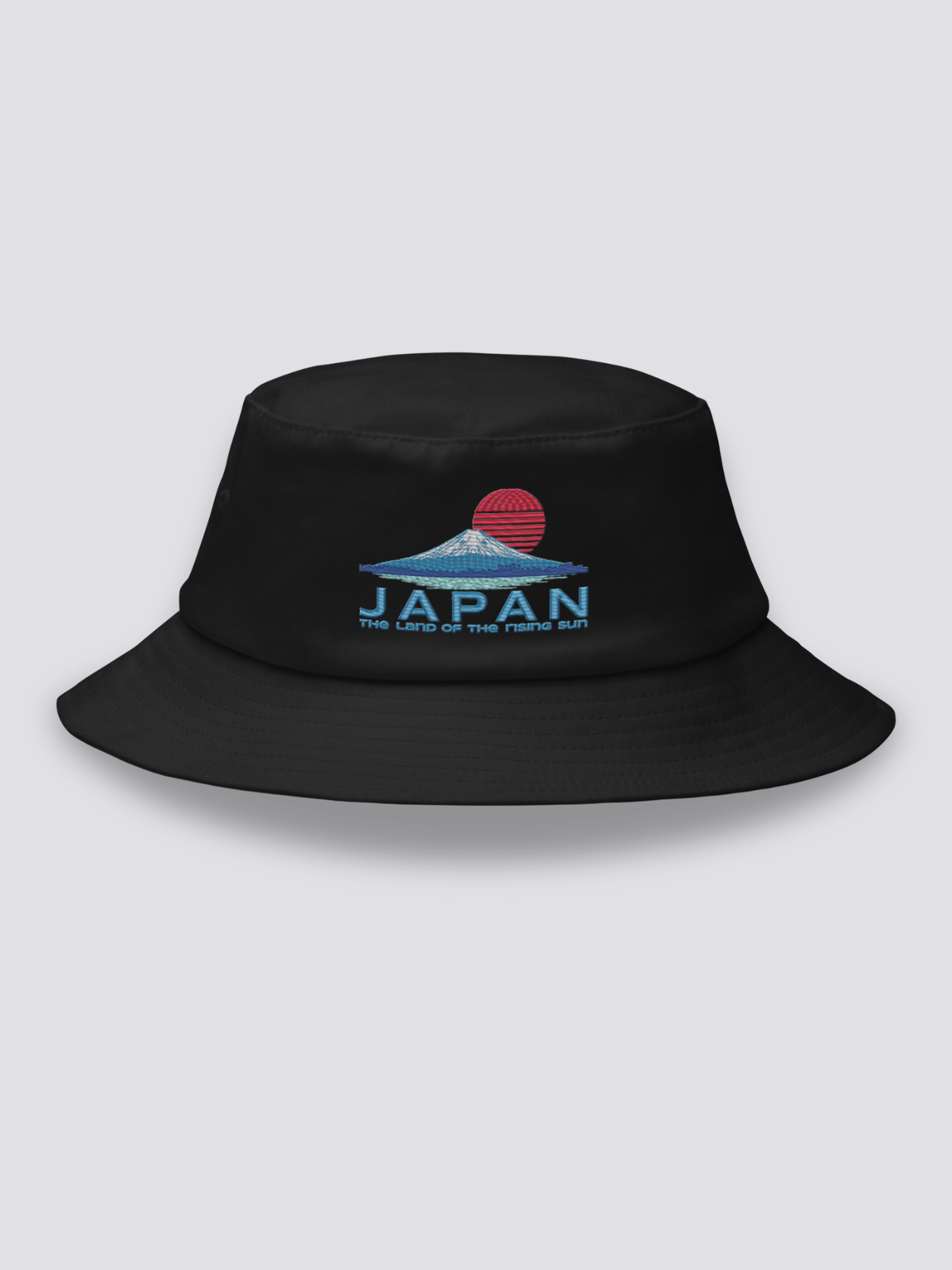 Black bucket hat with an embroidered striped red sun above a deep blue Mount Fuji and JAPAN lettering in navy