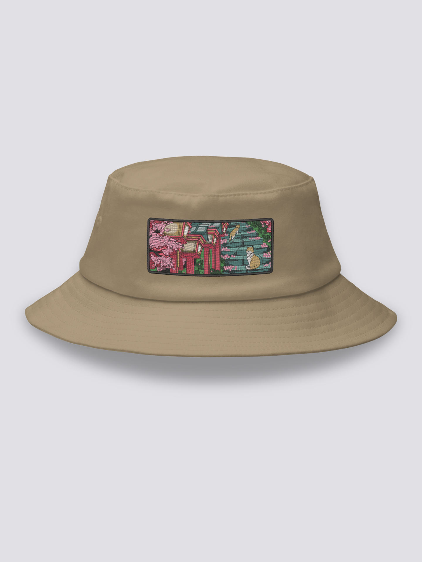 White bucket hat with an embroidered patch of stone shrine steps under cherry blossom with two orange and white cats