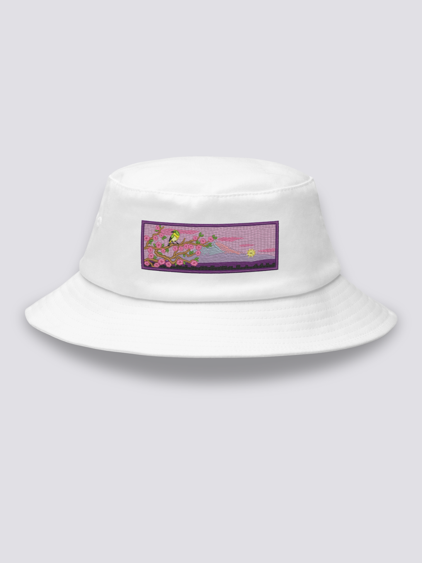 White bucket hat with an embroidered patch of a warbler on a cherry branch before Mount Fuji at dusk