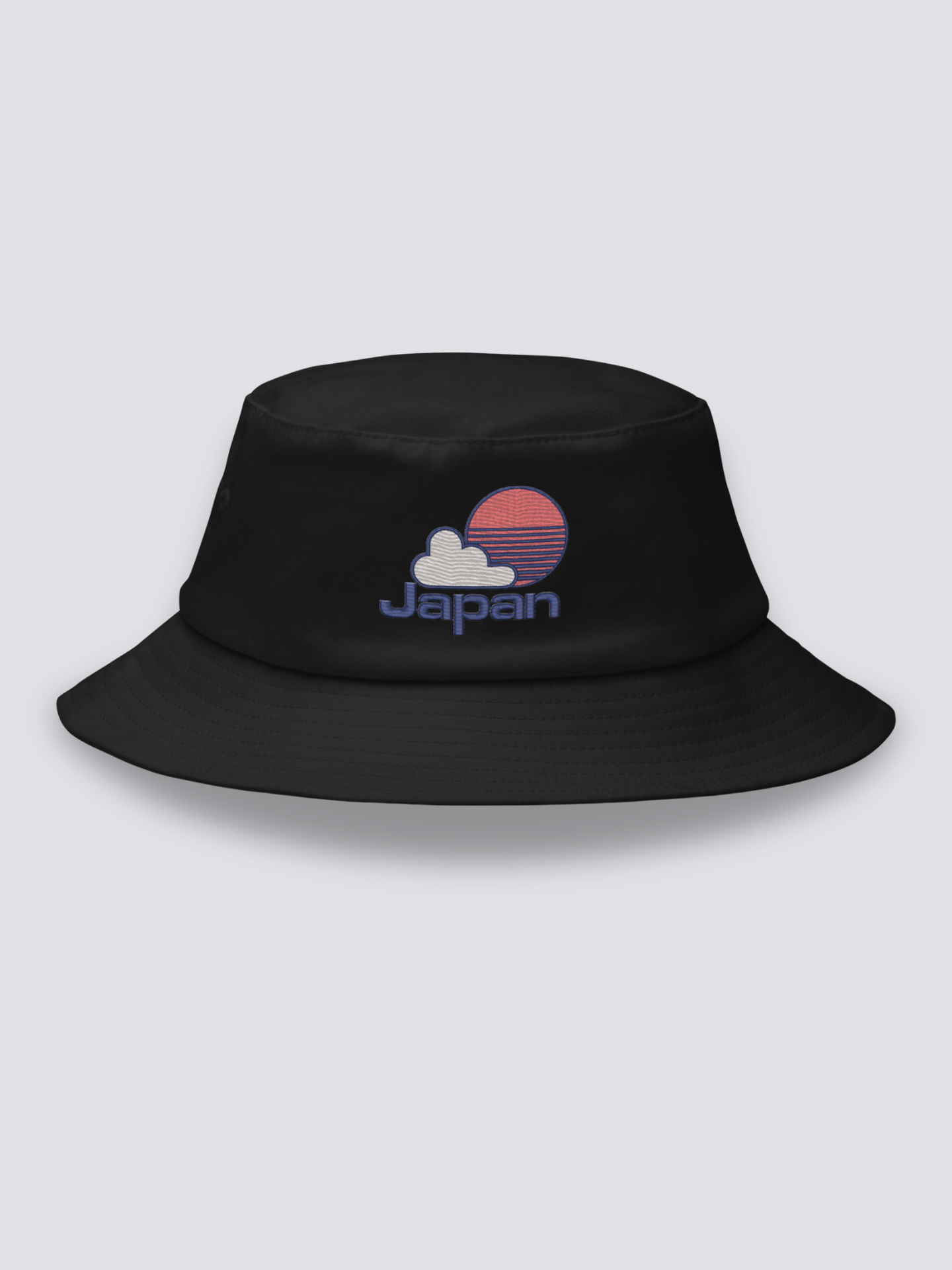 Black bucket hat with an embroidered red striped sun behind a white cloud above JAPAN in navy lettering
