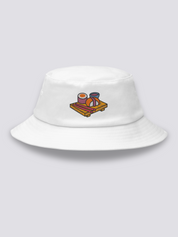 Khaki bucket hat with an embroidered wooden serving board holding a maki roll, a nigiri, pink chopsticks and a bowl of soy sauce