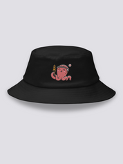 Black bucket hat with an embroidered smiling coral-pink octopus wearing a hachimaki headband and holding a takoyaki skewer