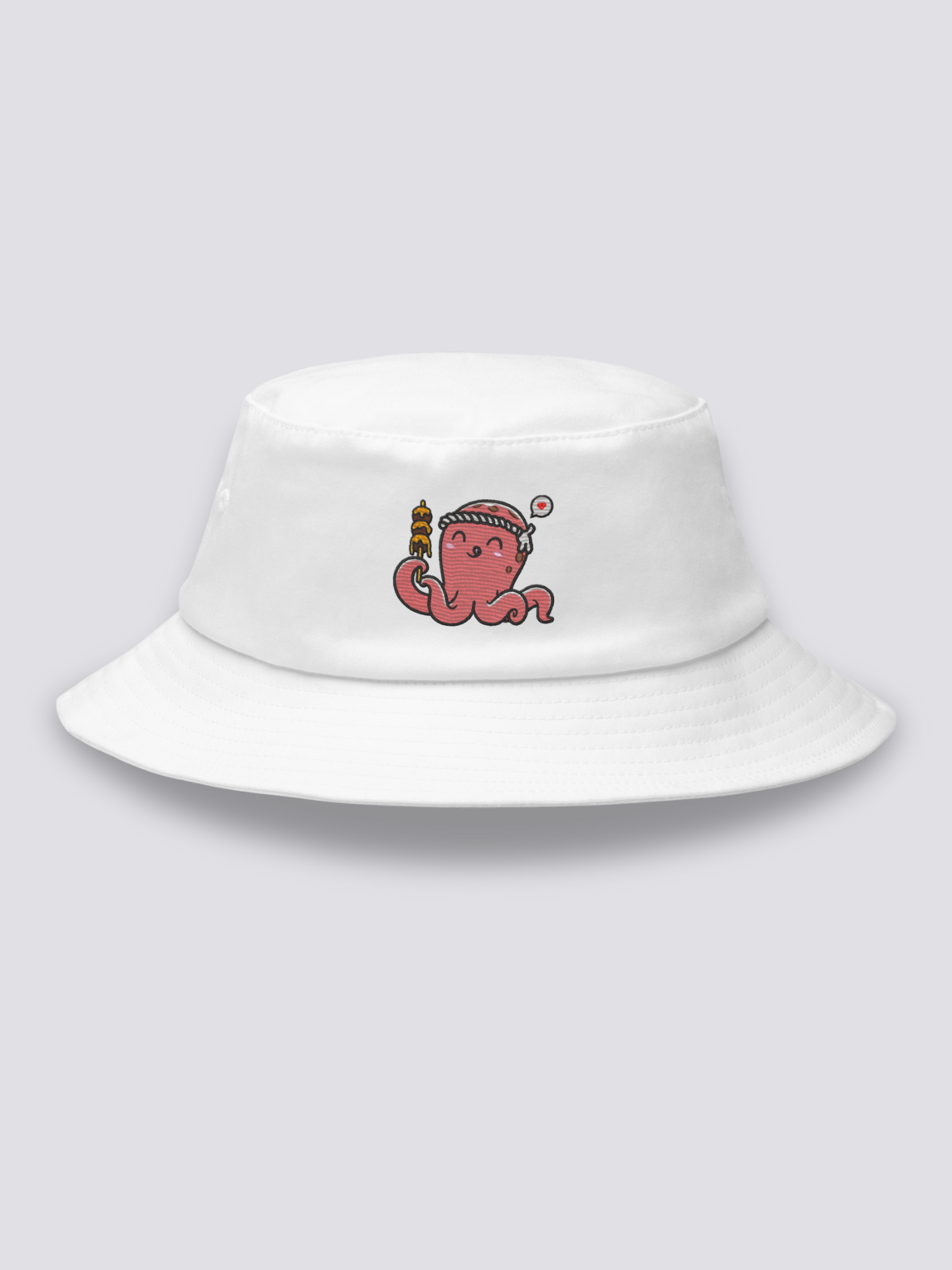 White bucket hat with an embroidered smiling coral-pink octopus wearing a hachimaki headband and holding a takoyaki skewer