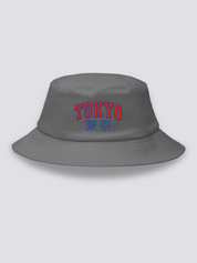 Grey bucket hat with TOKYO embroidered in arched red varsity capitals above the navy kanji 東京