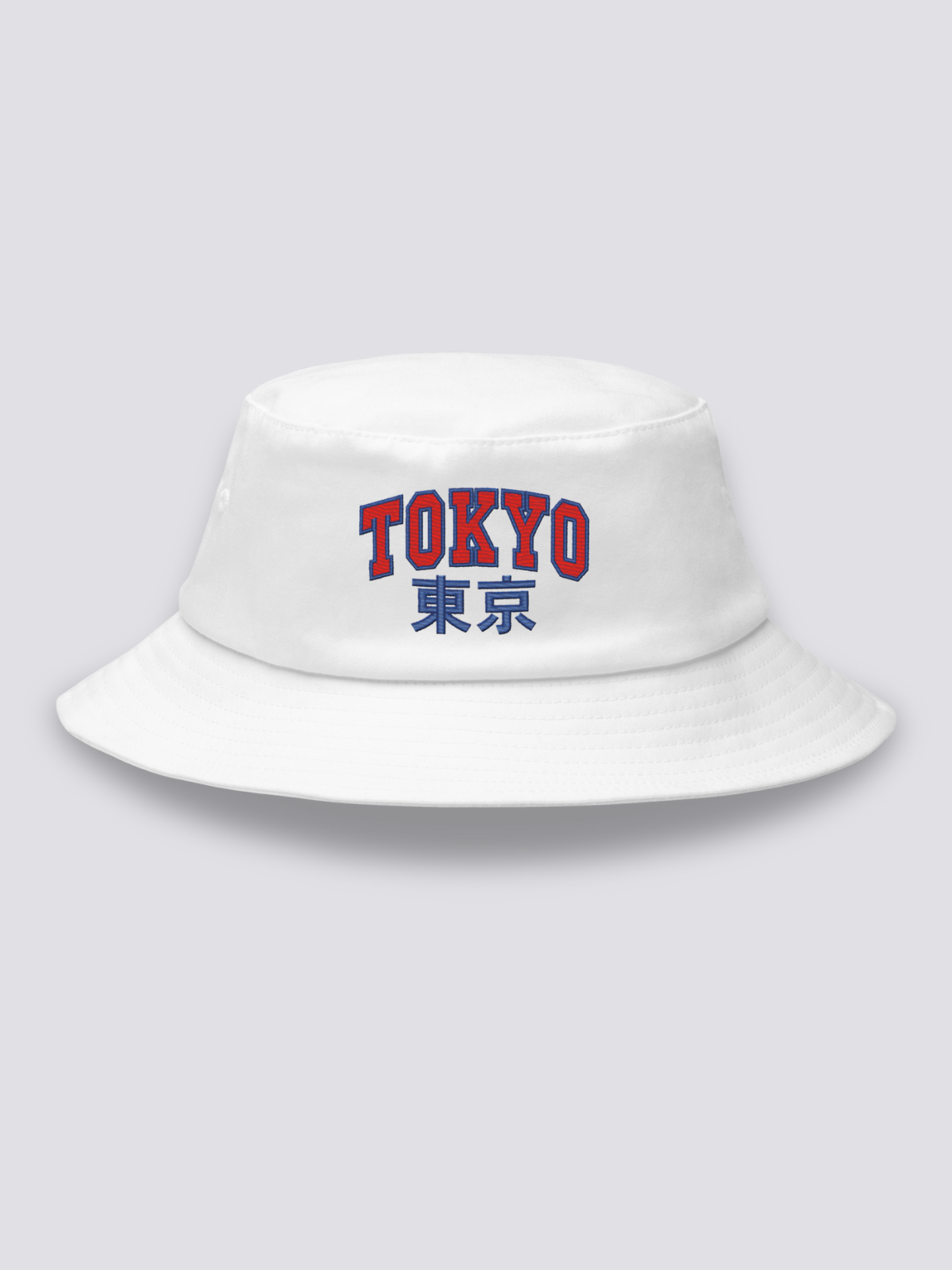 White bucket hat with TOKYO embroidered in arched red varsity capitals above the navy kanji 東京