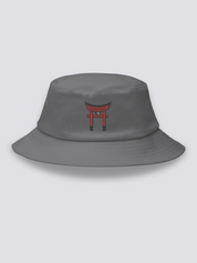 White bucket hat with a single vermilion torii gate embroidered in a minimal architectural study