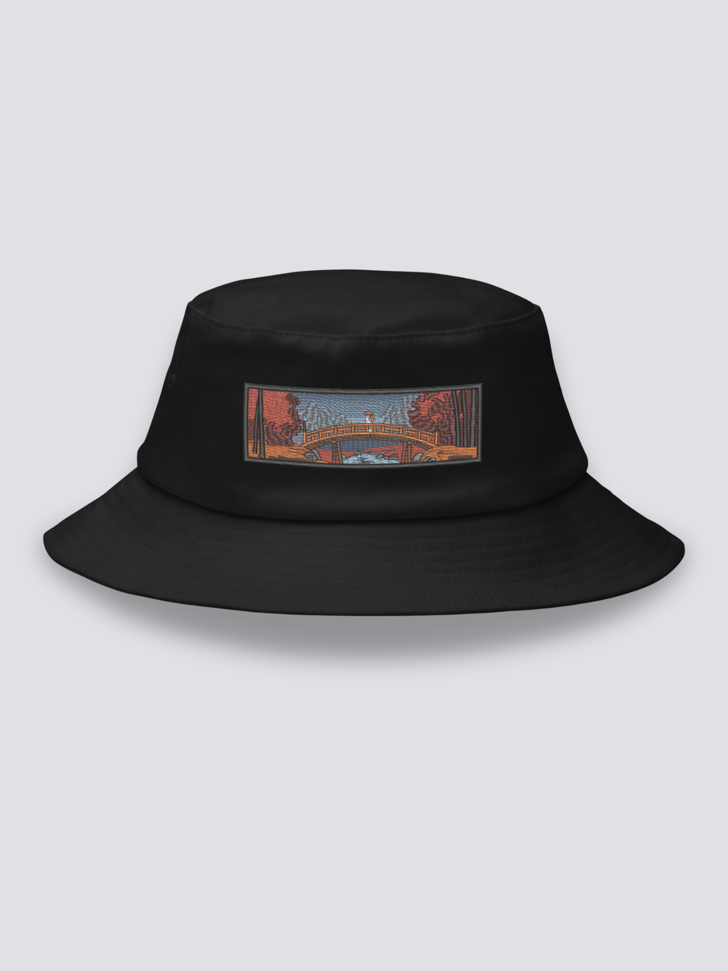 Black bucket hat with an embroidered patch of an arched taikobashi bridge under red autumn maples