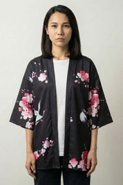 Geisha kimono jacket Sakura x Geiko in black, front view: open jacket with three-quarter sleeves and pink cherry blossom drifting across the panels