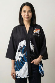 Great Wave off Kanagawa kimono jacket, front view: open black kimono with three-quarter sleeves and blue wave detail on the panels