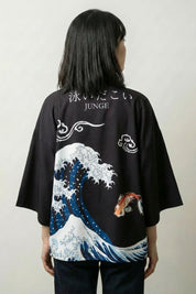 Back view of the Great Wave kimono: Hokusai's towering crest of blue and white foam with koi carp swimming up through it and brushed calligraphy above