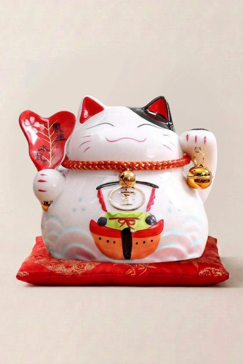 Japanese Cat Money Box 'Maple Leaf' — Japanese maneki-neko lucky cat money box, white ceramic lucky cat holding a red fan and a small drum on a red cushion