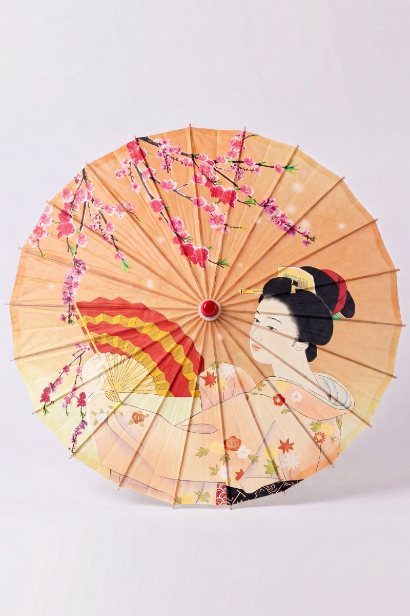 Traditional Japanese paper umbrella with a woman holding a folding fan among cherry blossom on a peach-apricot ground, shown open on bamboo ribs