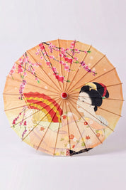 Traditional Japanese paper umbrella with a woman holding a folding fan among cherry blossom on a peach-apricot ground, shown open on bamboo ribs