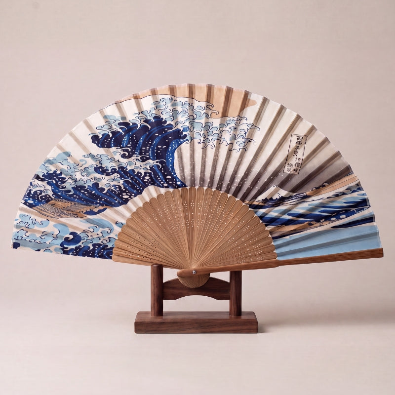 Japanese folding fan with the Great Wave of Kanagawa, a great blue curling wave against a pale sky, on bamboo ribs