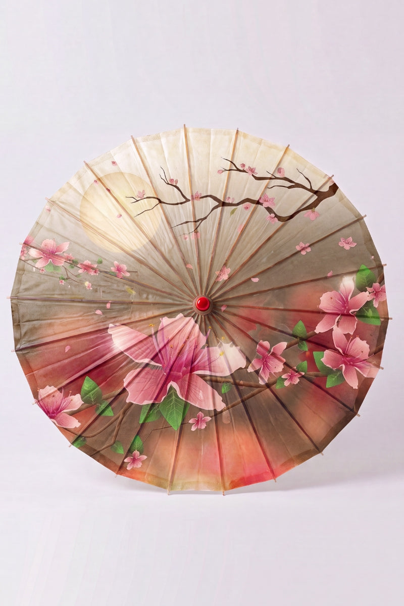 Traditional Japanese paper umbrella with pink blossom drifting past a pale full moon on a soft gray-and-rose ground, shown open on bamboo ribs