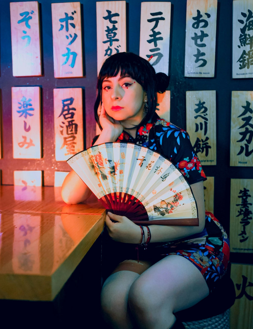 Woman wearing Japanese floral dress holding a traditional fan in a Tokyo-inspired setting — Japanstreet Community.