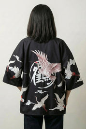 Back view of the black Haruko kimono jacket: a crimson bird with flared wings around a calligraphic seal set in a circle