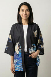 Kimono jacket Sanaé in black, front view: blue and gold wave print on an open three-quarter sleeve jacket