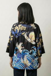 Back view of the black Sanaé kimono jacket, the gilded waves and crane glowing against the dark ground