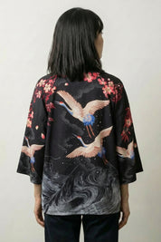 Back view of the Harumi kimono top: cranes wheeling in flight above a swirling grey whirlpool that spirals down to the hem