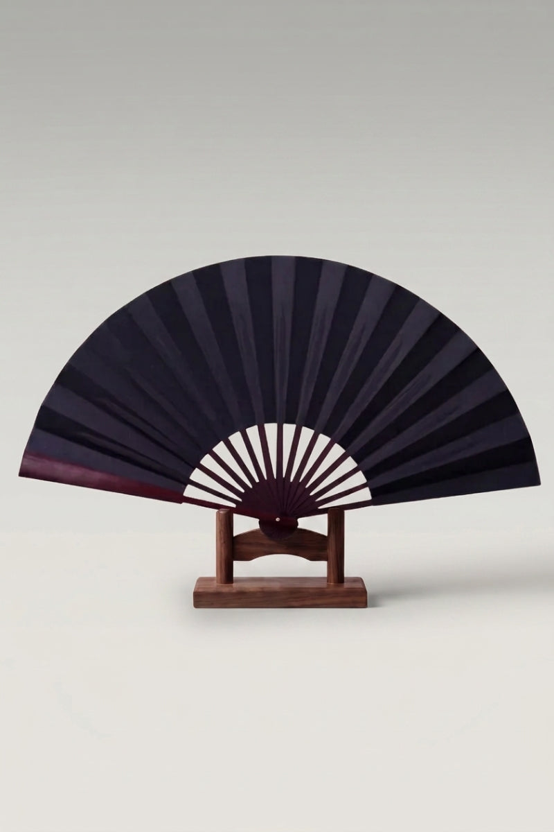 Large Japanese folding fan 'Kisho' — an oversized plain black leaf on a large bamboo folding fan, shown open on a wooden stand
