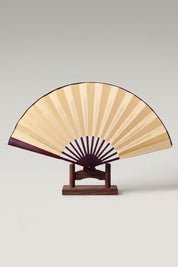 Large Japanese folding fan 'Kisho' — an oversized plain gold leaf on a large bamboo folding fan, shown open on a wooden stand