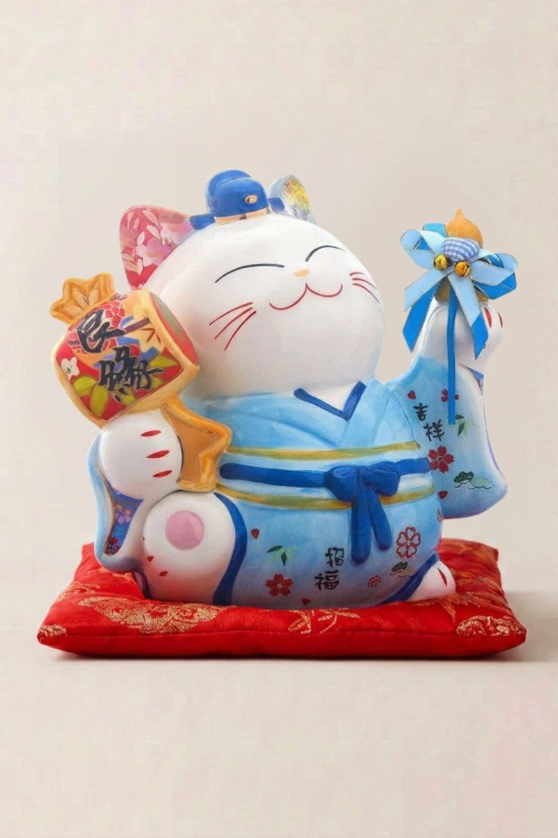 Maneki Neko Money Box 'Blue Fortune' — Japanese maneki-neko lucky cat money box, white ceramic lucky cat in a blue kimono holding a golden mallet on a red cushion