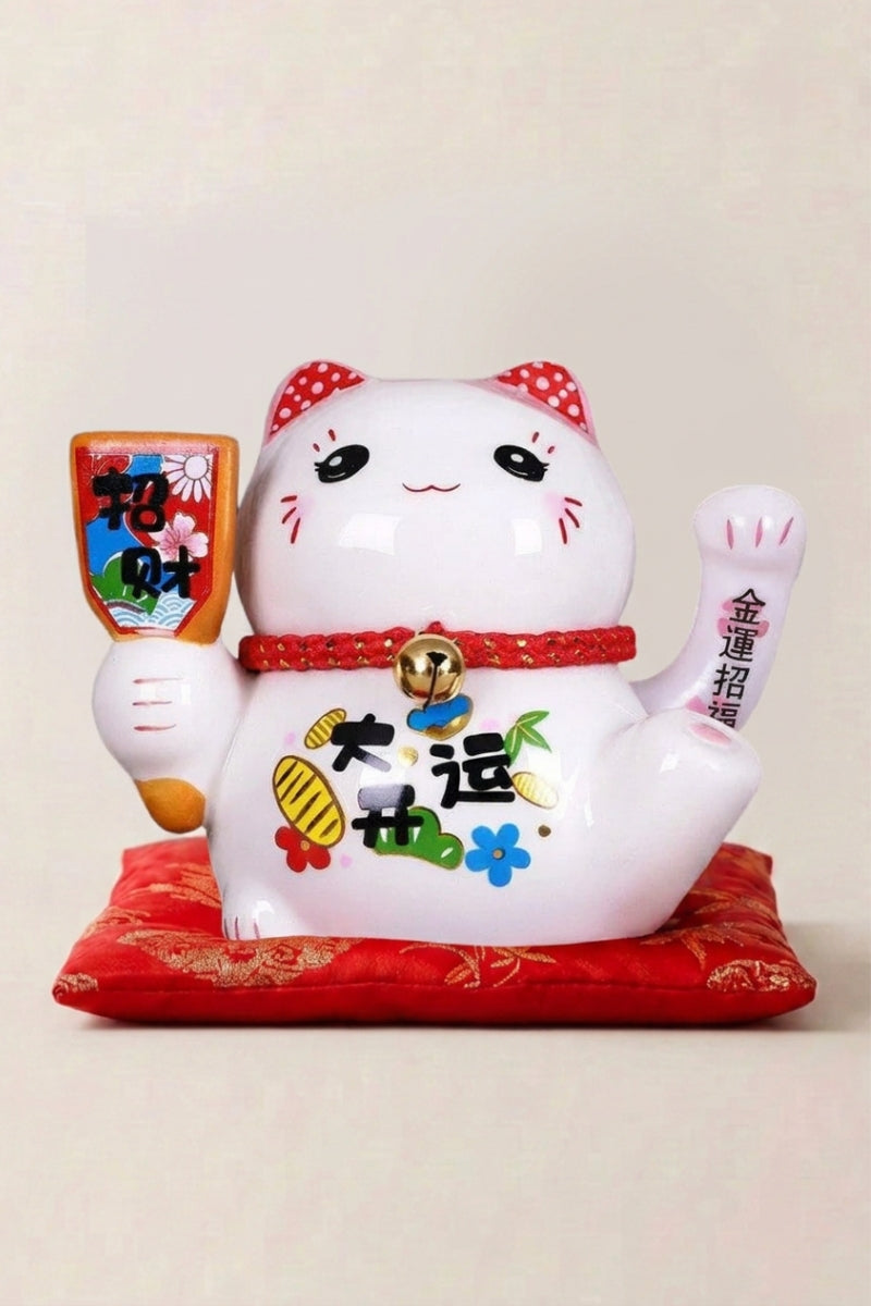 Maneki Neko 'Peace and Love' — Japanese maneki-neko lucky cat money box, white ceramic lucky cat with a red hood holding a fortune plaque on a red cushion