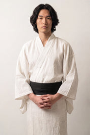 Matte solid black obi belt in thick fabric with a clean pre-formed knot, worn over a white kimono
