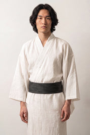 Deep navy-black obi belt flecked with fine pale gray dashes, worn over a white kimono