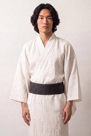 Dark teal obi belt with fine gray vertical striations, worn over a white kimono