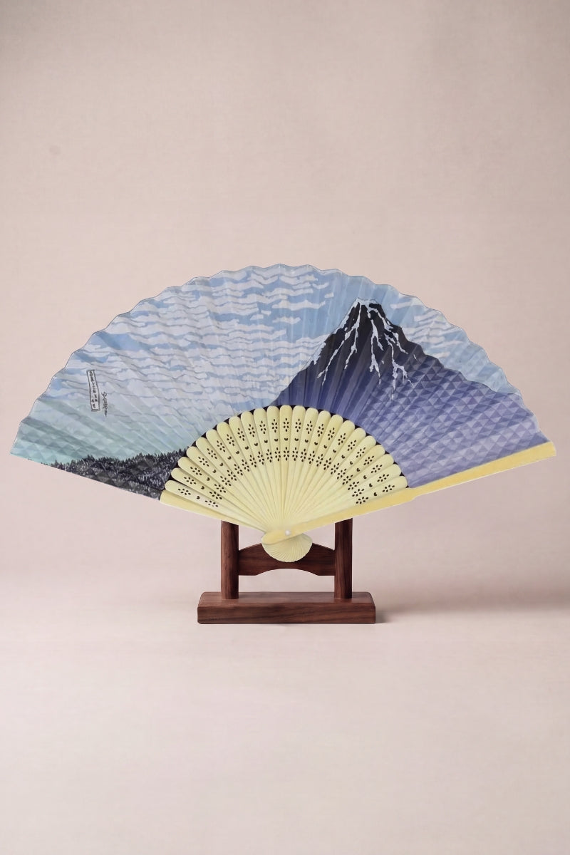 Japanese folding fan with a softly painted Mount Fuji landscape on pale straw-yellow bamboo ribs
