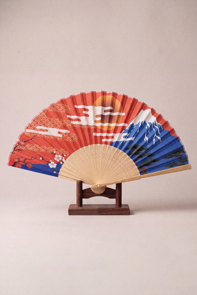 Japanese folding fan with Mount Fuji, a rising sun and gold seigaiha waves on red and blue, on bamboo ribs