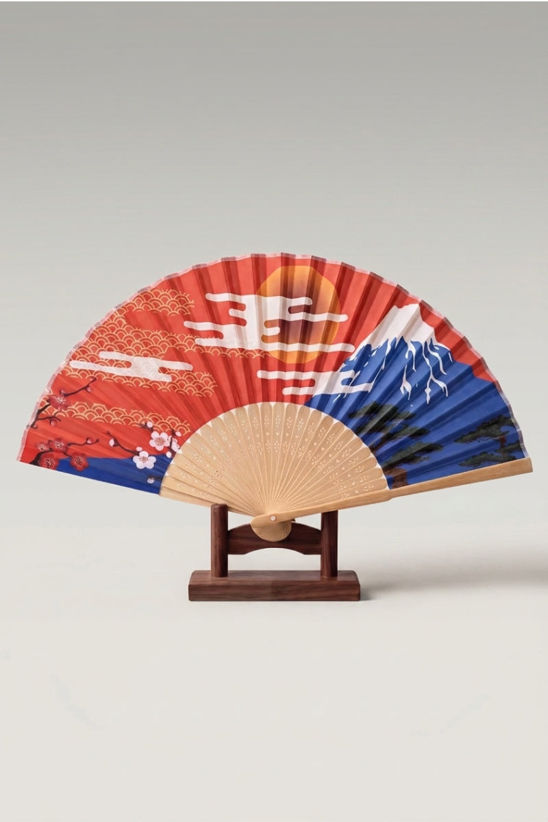 Japanese folding fan 'Minamato' — Mount Fuji and a rising sun with gold waves on a red folding fan, shown open on a wooden stand