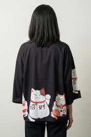 Back view of the black Maneki Neko kimono cardigan, the beckoning cat and fortune characters bright against the dark ground