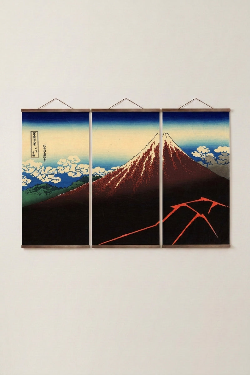 Antique Japanese painting 'Fuji Hakuro' — Japanese ukiyo-e-style print depicting a red Mount Fuji under a storm with lightning at its base, as a three-panel triptych wall art, shown on a wall